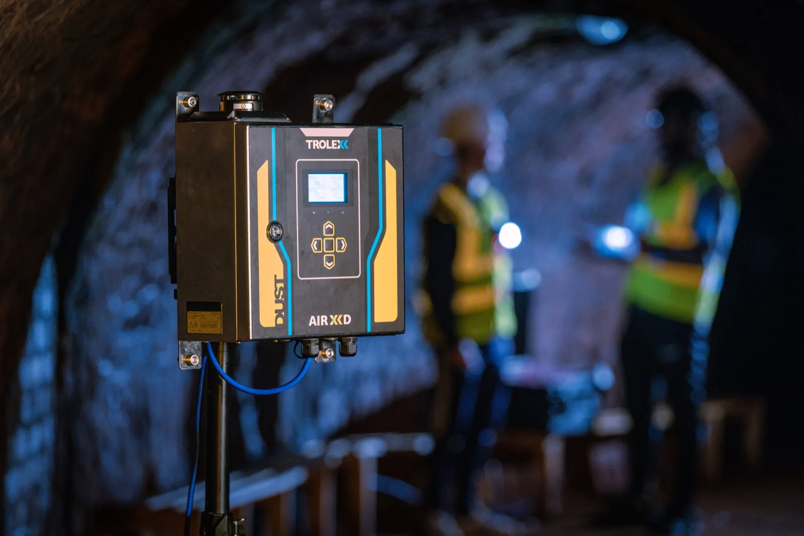 Detector de polvo respirable TROLEX AIR XD montado en un túnel de mina, con operarios de seguridad al fondo